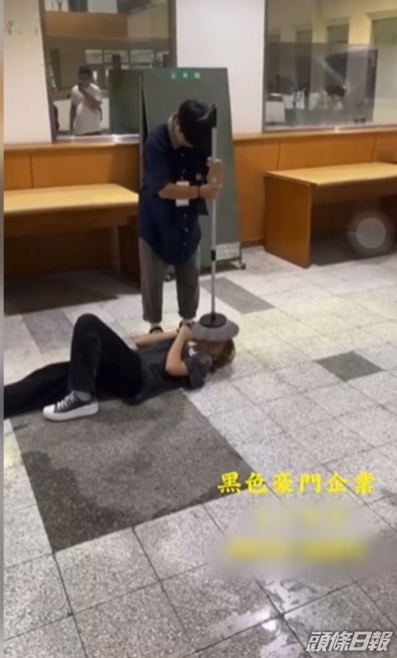 男生拿起地拖「質」向躺在地上的女生臉上。