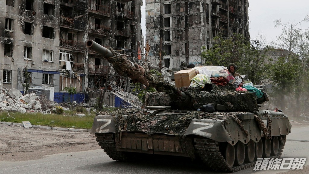 親俄軍的軍人在盧甘斯克州街道上駕駛一輛坦克。REUTERS