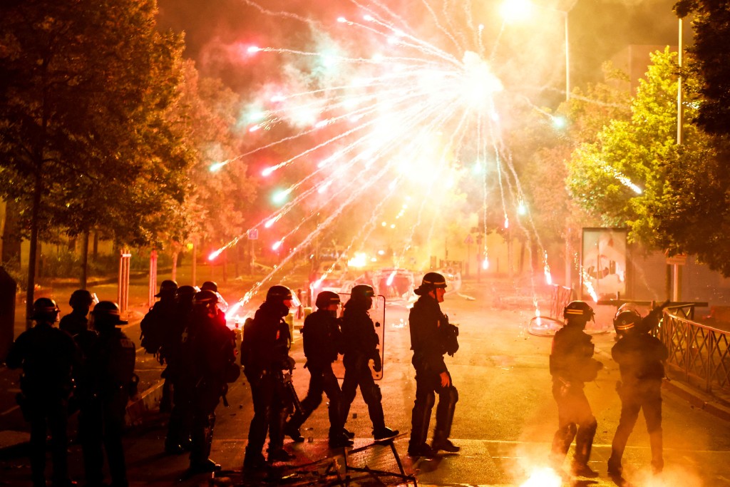 法國警察與示威者衝突中，有人施放煙花。路透社