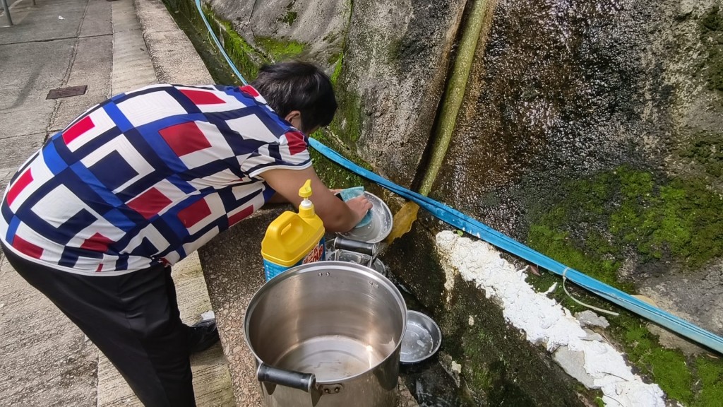 多名居民到山邊取山水洗碗碟。黃文威攝 多名居民到山邊取山水洗碗碟。黃文威攝
