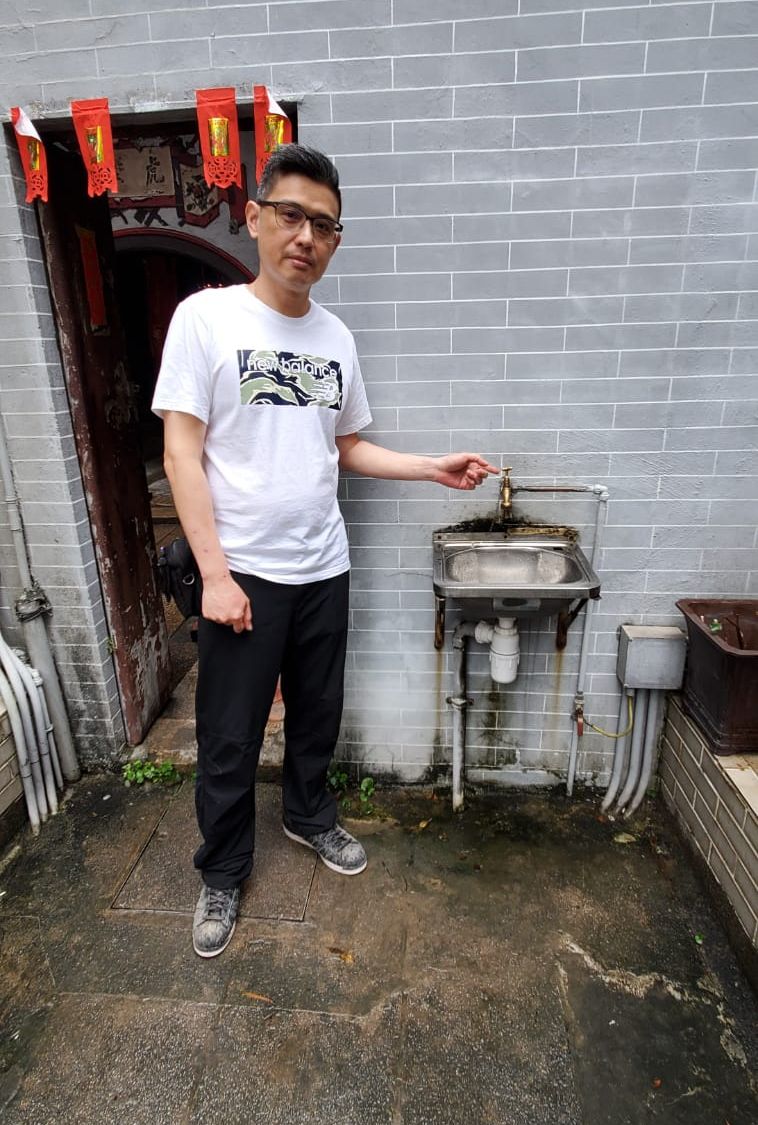 戴廟祝指示疑被偷取食水的水龍的水喉位置。楊偉亨攝