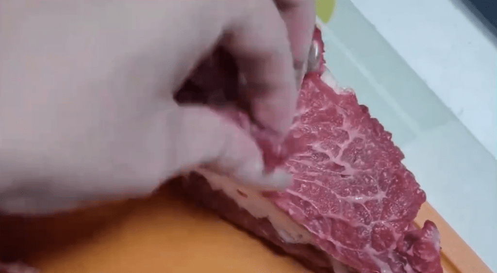 牛油上撕出一片片瘦肉。