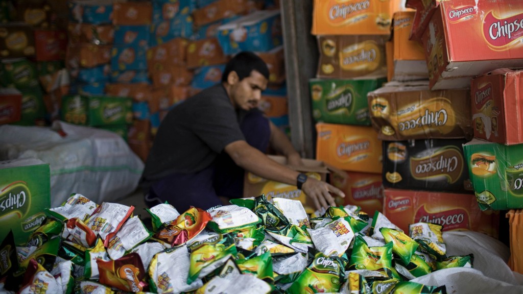 一名巴勒斯坦男子将来自埃及的走私薯片拆箱。 美联社