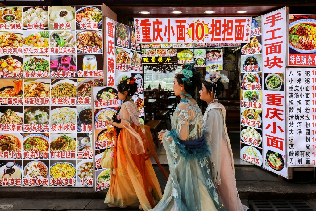幾名漢服姑娘從重慶一家麵館前走過。 路透社