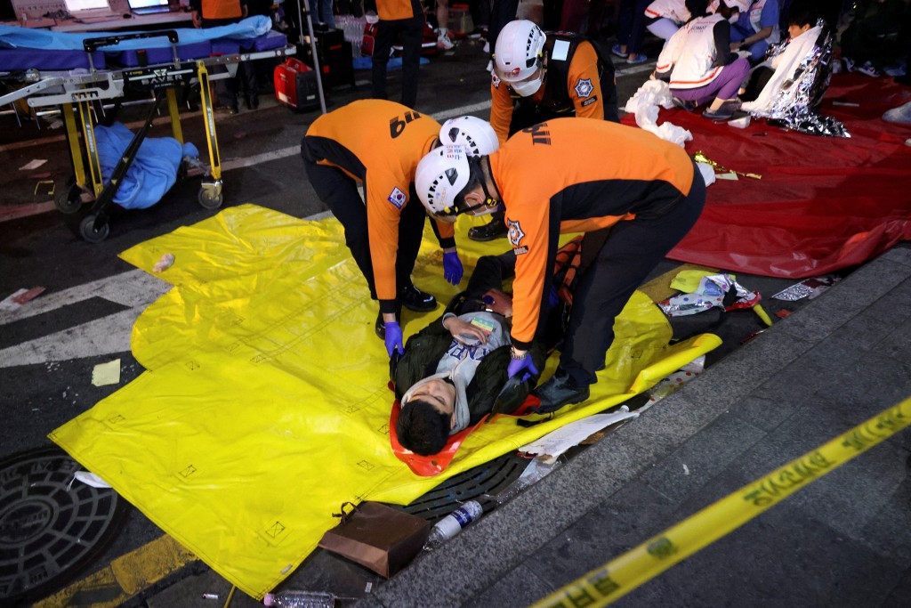 救援人员将伤者移上担架。路透社