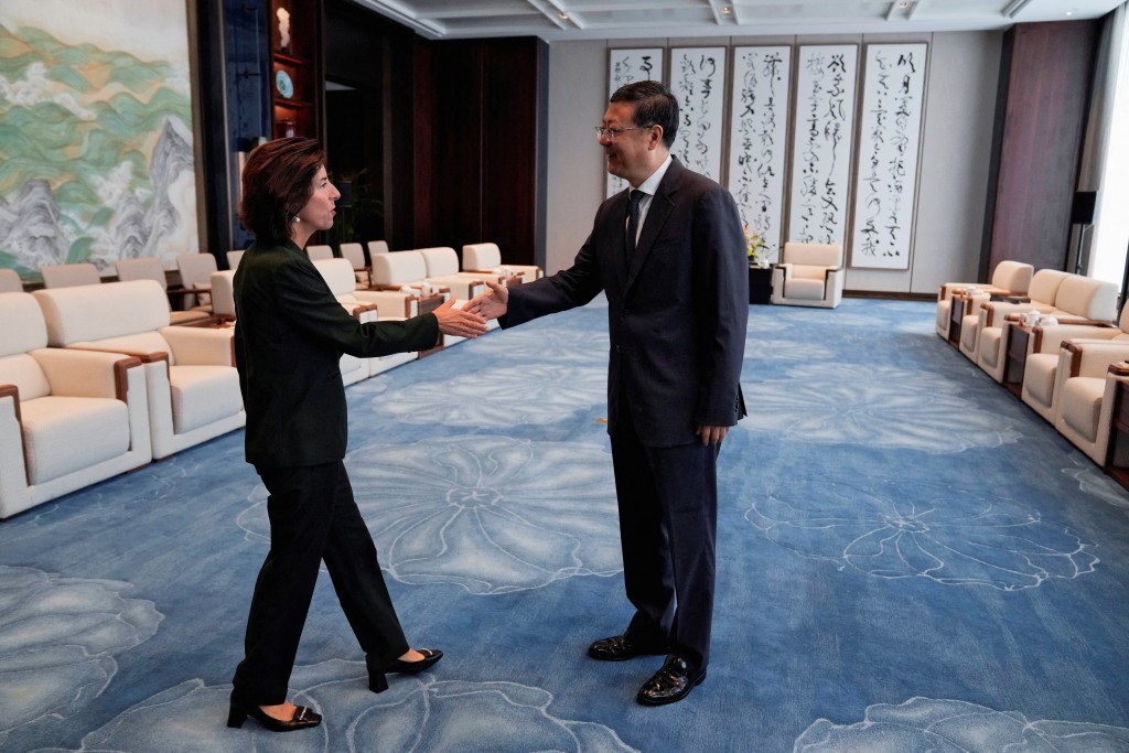 上​​海市委書記陳吉寧與美國商務部長雷蒙多握手。路透社