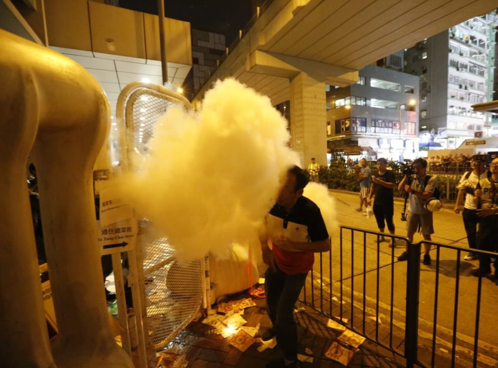 有人在封鎖範圍外點香燭,被防暴警員用滅火筒噴熄。