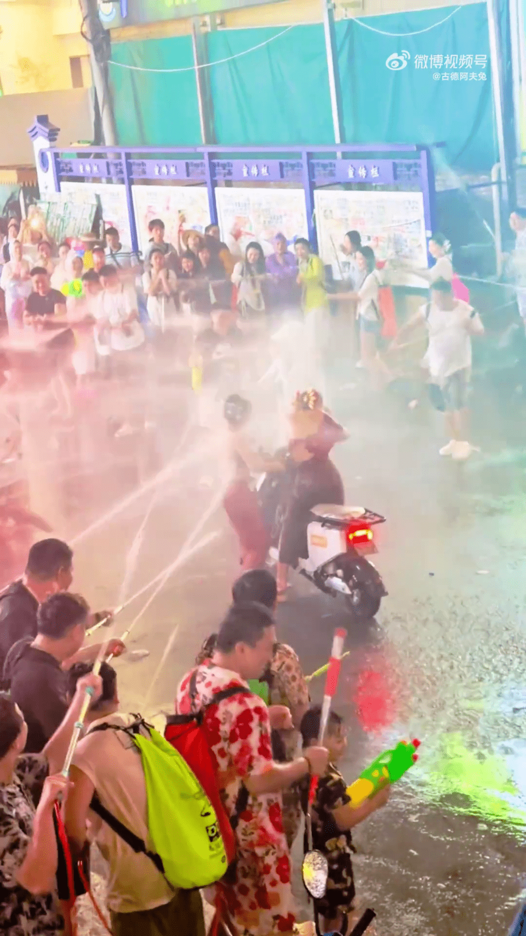 云南泼水节,两女遭高压水枪狂喷,其中一人突围失败折返。 云南泼水节,两女遭高压水枪狂喷,其中一人突围失败折返。
