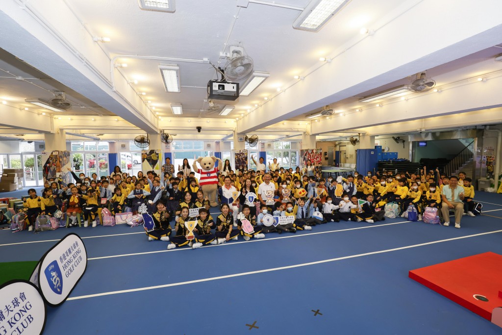 香港哥爾夫球會會長郭永亮、聖公會榮真小學楊靄筠校長、GOLFZON 銷售及營 運總監司徒浩南在啟動禮與老師及學生大合照。公關圖片