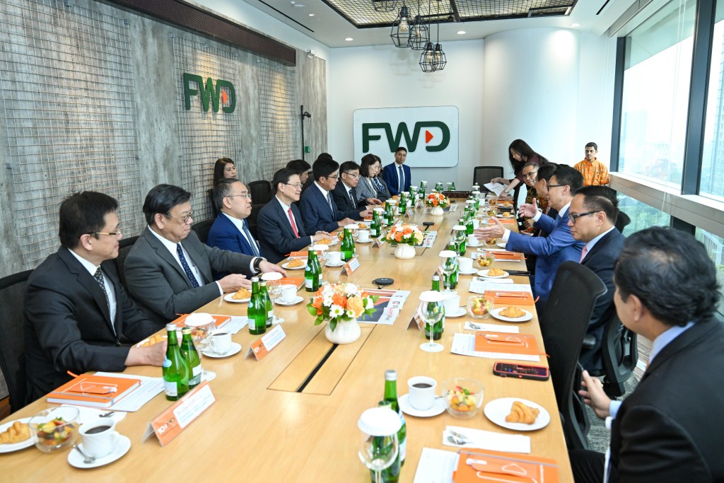 李家超（左四）与特区代表团在印尼雅加达参观香港保险企业富卫集团设在当地的办事处。政府新闻处图片