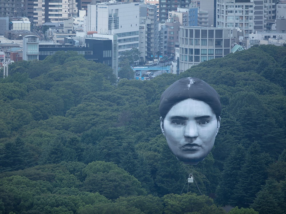 日本東京的天空今日出現一個巨型人頭熱氣球，高度約7層樓。twitter圖片