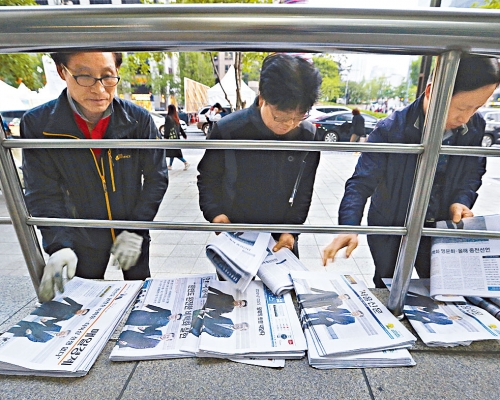 南韓工人在首爾街頭整理出售的報章。 資料圖片
