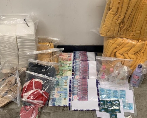 警方在元朗掃黃行動中,檢獲現金及避孕套等證物。