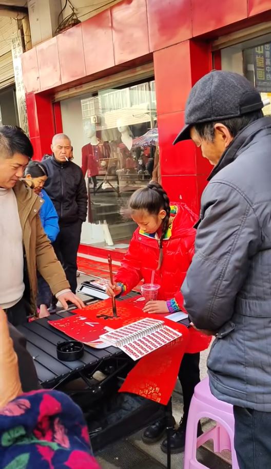 湖北11歲蔣夢涵當街賣手寫春聯，賺錢之餘又可練膽克服「社恐」。