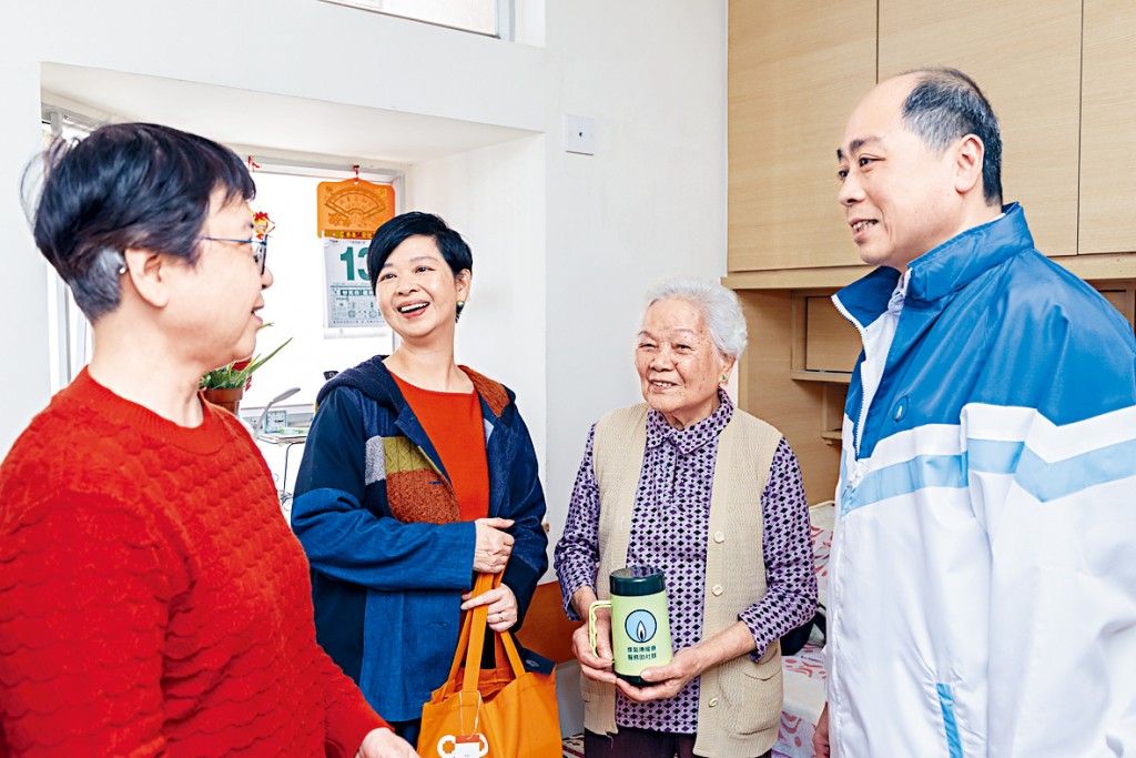 房屋局局長何永賢（左二）與我在上月中一同探訪獲贈「浴暖寶」的公屋長者戶。