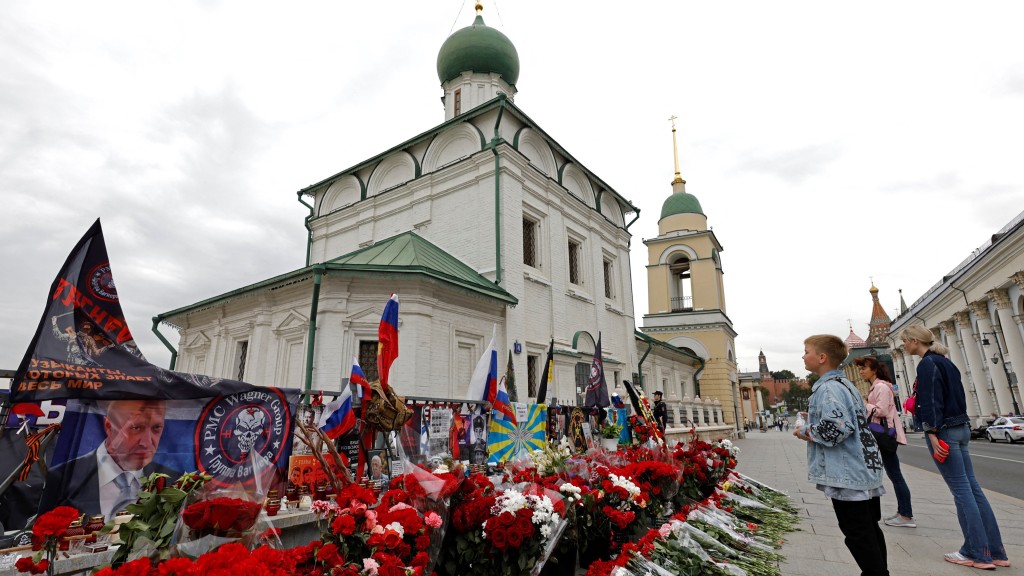 莫斯科民众在临时纪念站前悼念普里戈任和瓦格纳指挥官乌特金。 路透社