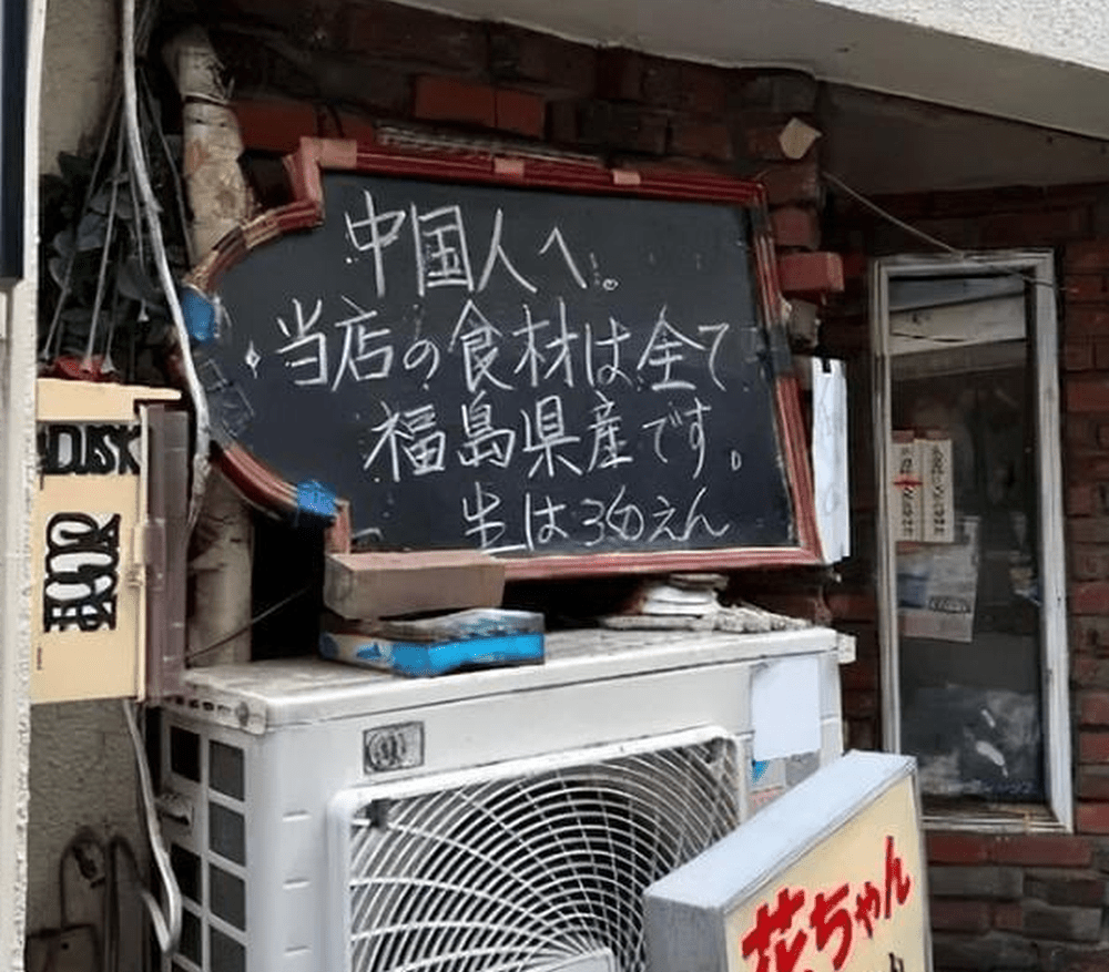 日本新宿地區一間居酒屋門前掛著寫著：「中國人，本店的食材全部來自福島。」的告示。