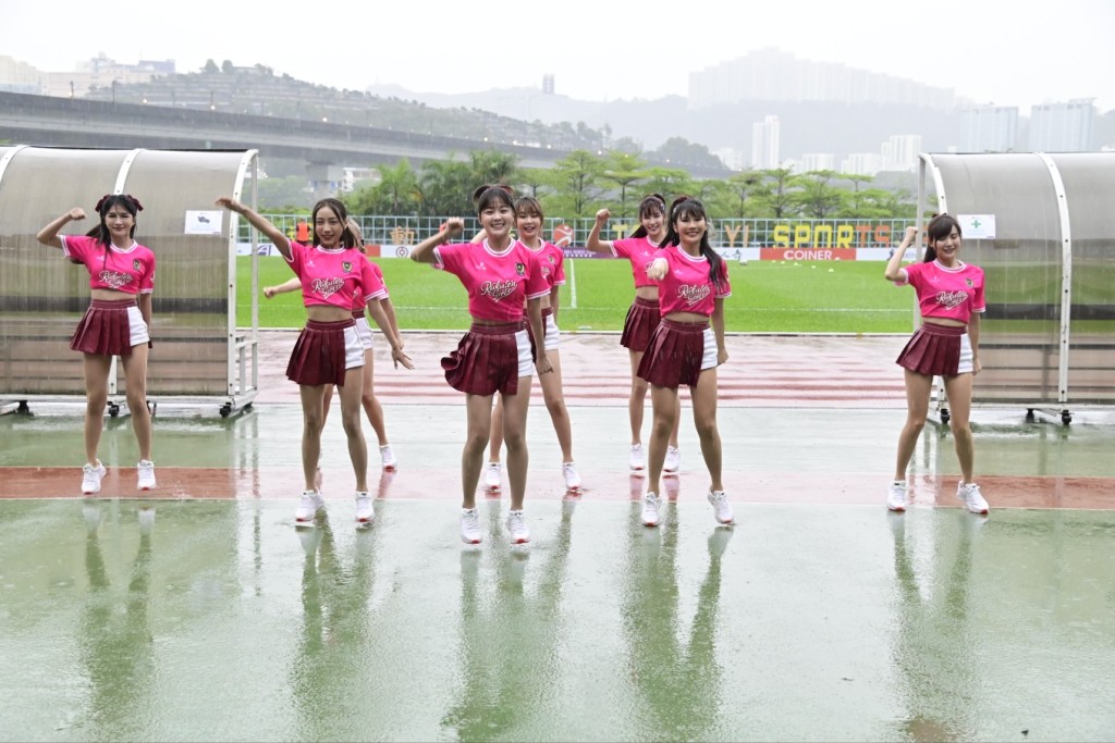 樂天女孩穿上粉紅色上衣及短裙褲，在雨中表演。