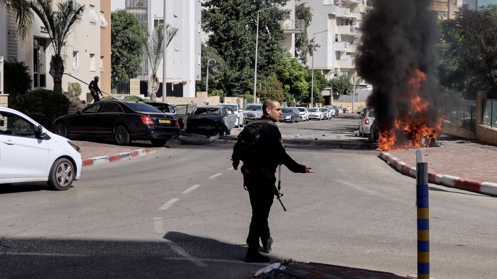 在以色列南部阿什凯隆，一名警员走向一处火场。 路透社