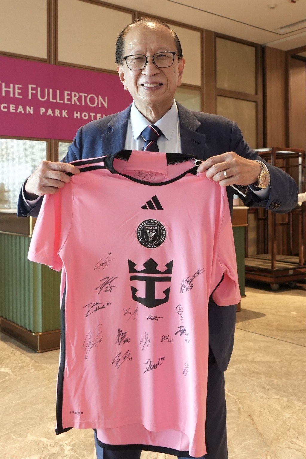 足总会长贝钧奇向记者展示球队签名球衣。刘骏轩摄