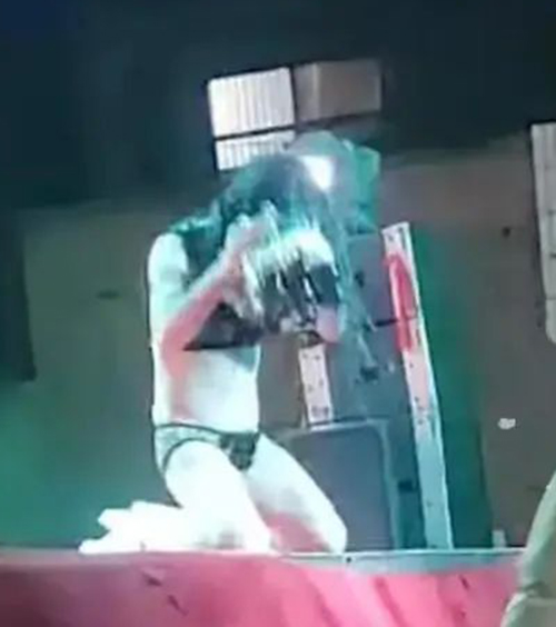 女子表演時衣著暴露，跪在舞台上，拿起啤酒往全身倒。