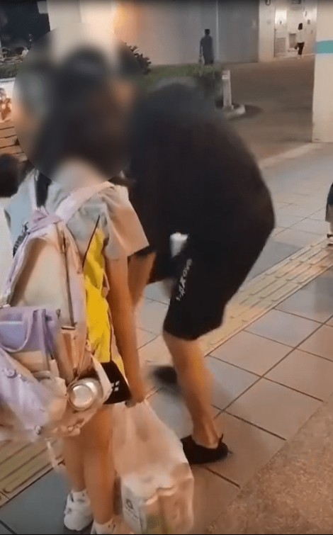當街坊質疑女童父親做法時,父親突回身抽走女童其中一袋啤酒。(Threads影片截圖) 當街坊質疑女童父親做法時,父親突回身抽走女童其中一袋啤酒。(Threads影片截圖)