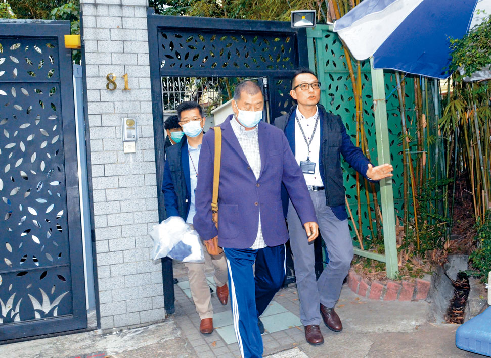 ■戴了口罩及穿上紫色西裝褸的黎智英，在其何文田寓所被探員帶走。