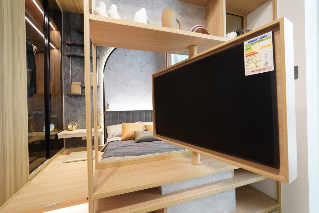 睡房与客厅之间以木制饰架作间隔，配以可360度旋转的电视架