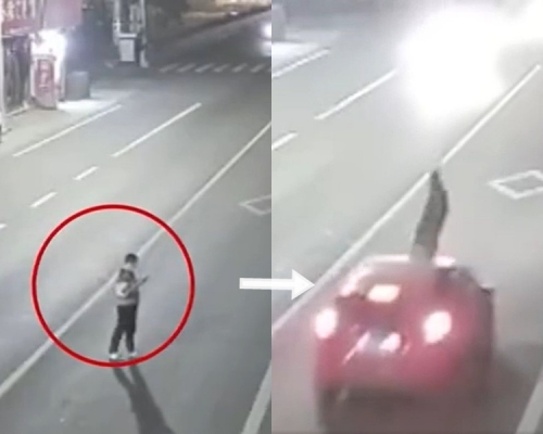 男子站在马路中间低头看手机，被车撞飞。影片截图