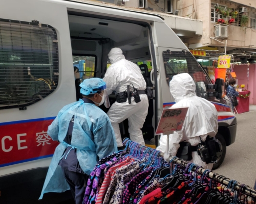 穿上保護袍，包括白色生化保護袍的警員今早到花園街198號調查走失確診病人。