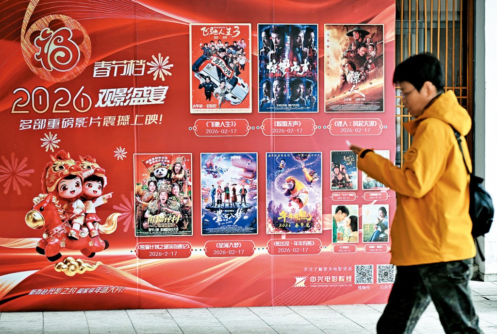 市民從福州一影院春節檔電影海報旁經過。