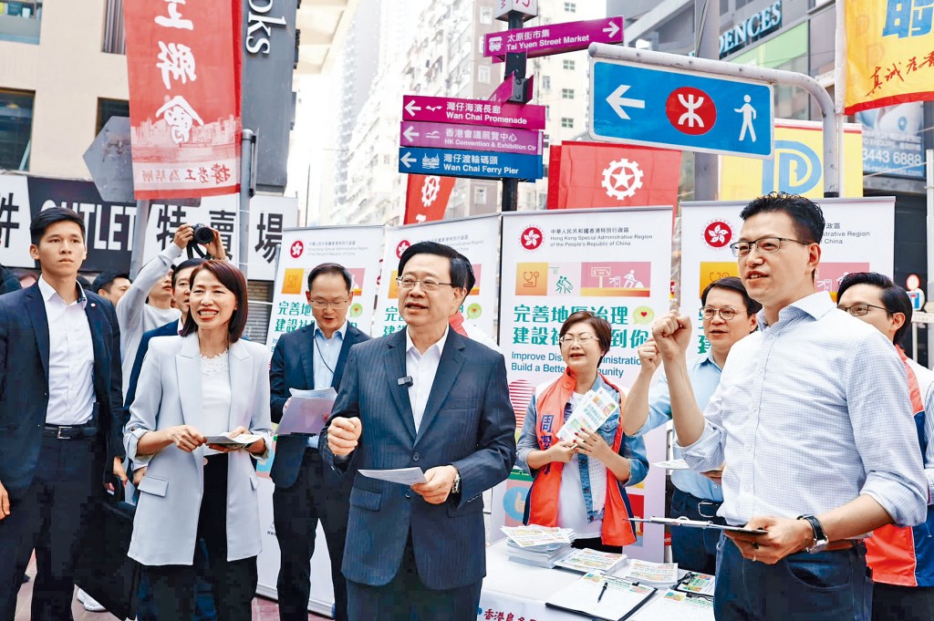 李家超昨晨返回辦公室前到訪銅鑼灣街站，為義工加油打氣。