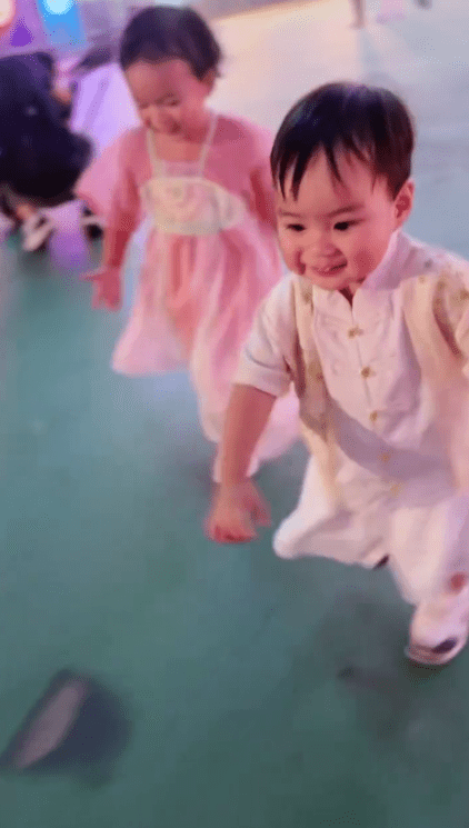 朱慧敏一對子女奔跑嬉戲，露出純真笑容。