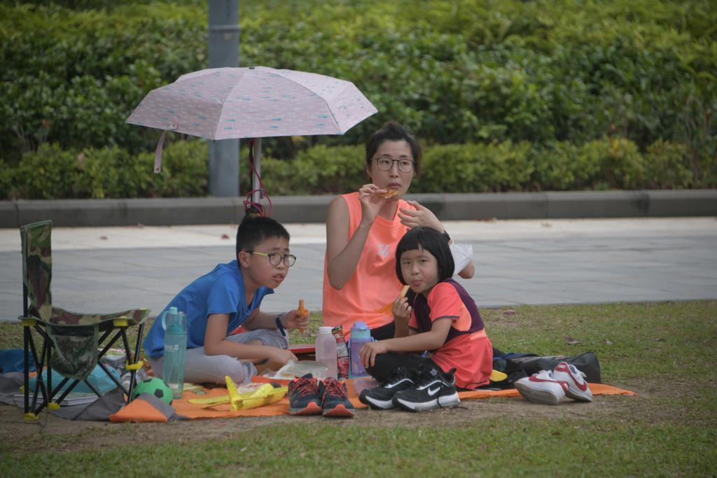 市民在公園草地上野餐紮營。