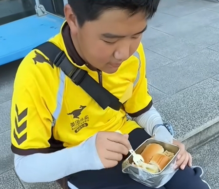 小郝当外卖员时忙得吃饭也没有时间,只在路边随便吃些东西。 小郝当外卖员时忙得吃饭也没有时间,只在路边随便吃些东西。