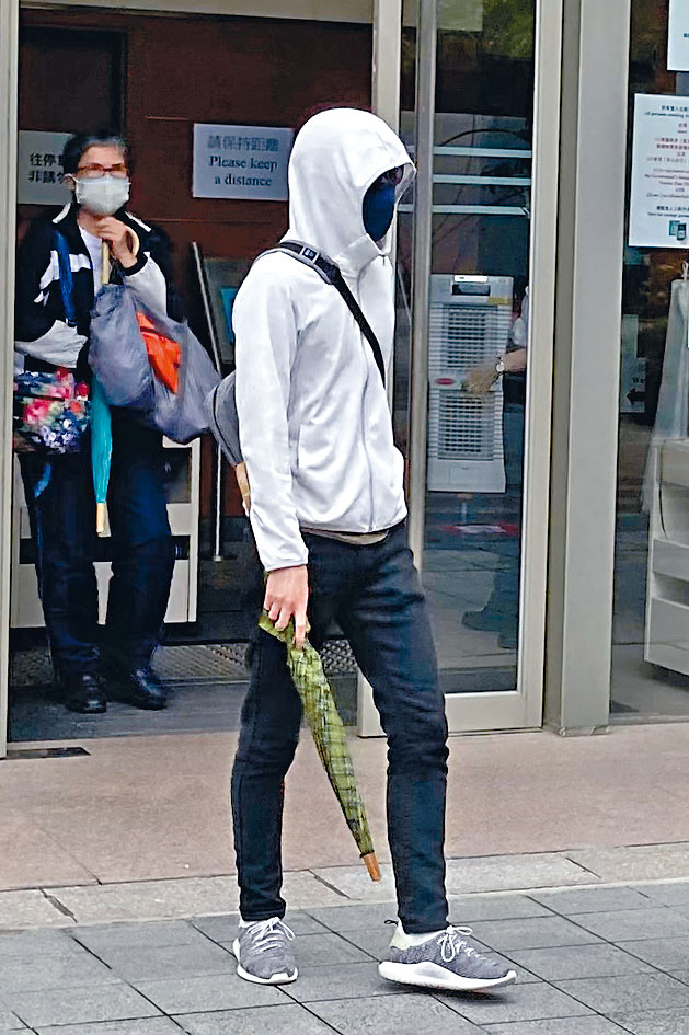 被告何牧華包裹全身，逃避傳媒鏡頭。,