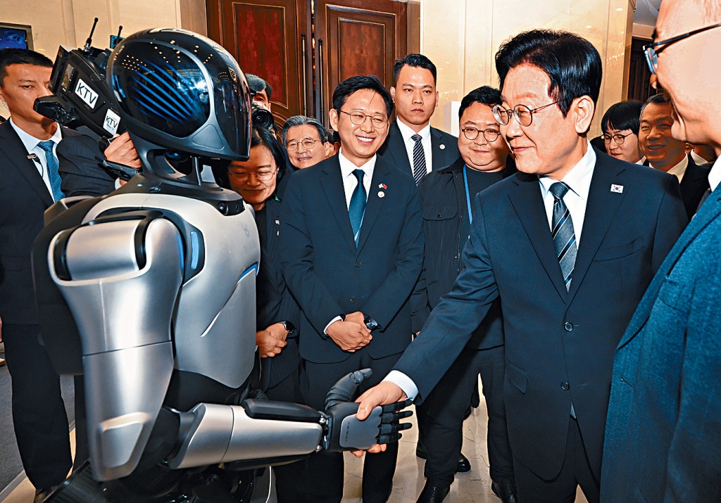 韓國總統李在明在上海出席中韓創新創業論壇，與中國機械人握手。