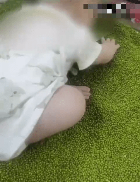 穿尿片的幼嬰在超市綠豆堆中抓著玩。 穿尿片的幼嬰在超市綠豆堆中抓著玩。