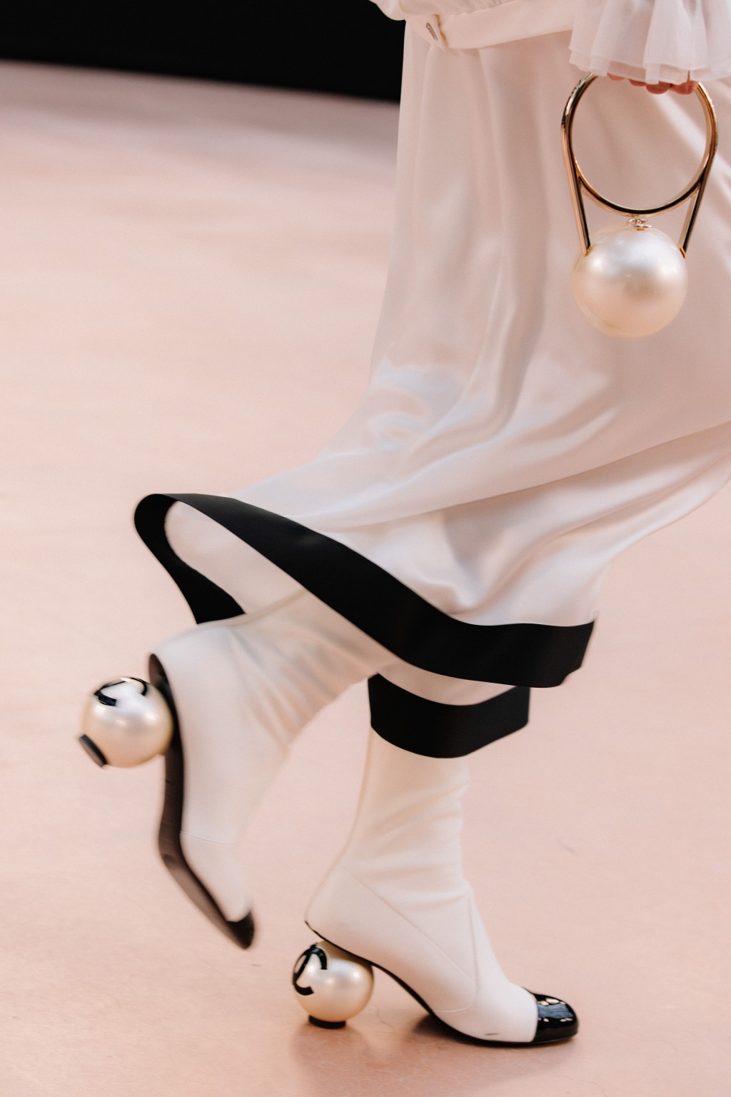Chanel新推的彈性小羊皮及漆皮 黑白雙色珍珠鞋跟中靴/$22,000。 