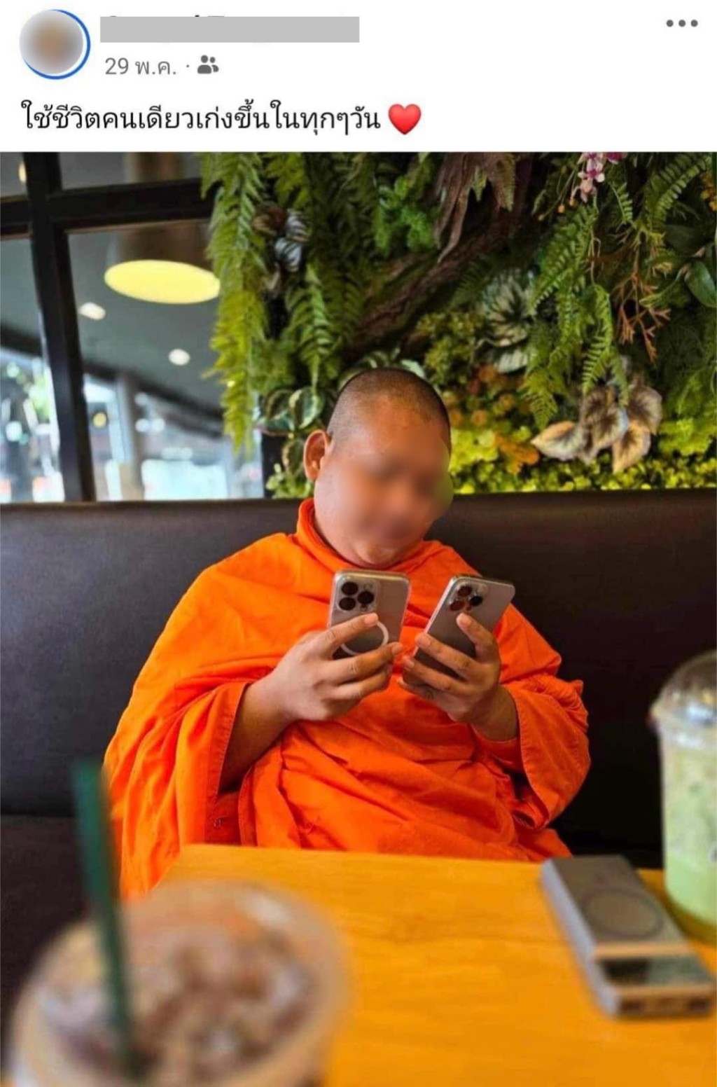 泰國僧侶拿着2部iPhone Pro閒坐咖啡廳。 facebook