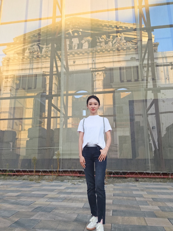 王芳在马里乌波尔大剧院废墟外留影。