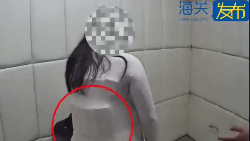 女子脱去外套后,上半身绑藏的异物浮现。 海关发布 女子脱去外套后,上半身绑藏的异物浮现。 海关发布