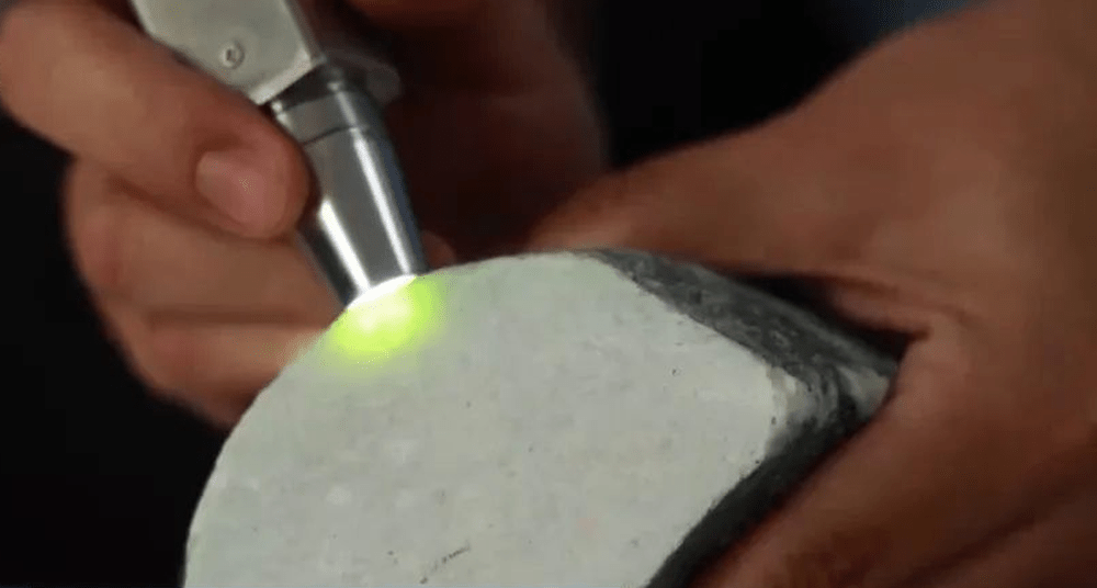 騙徒以電筒照出是否「翡翠原石」。 騙徒以電筒照出是否「翡翠原石」。