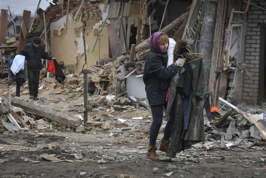 俄罗斯火箭袭击乌克兰扎波罗热，当地居民带着他们的物品离开被毁的家园。AP