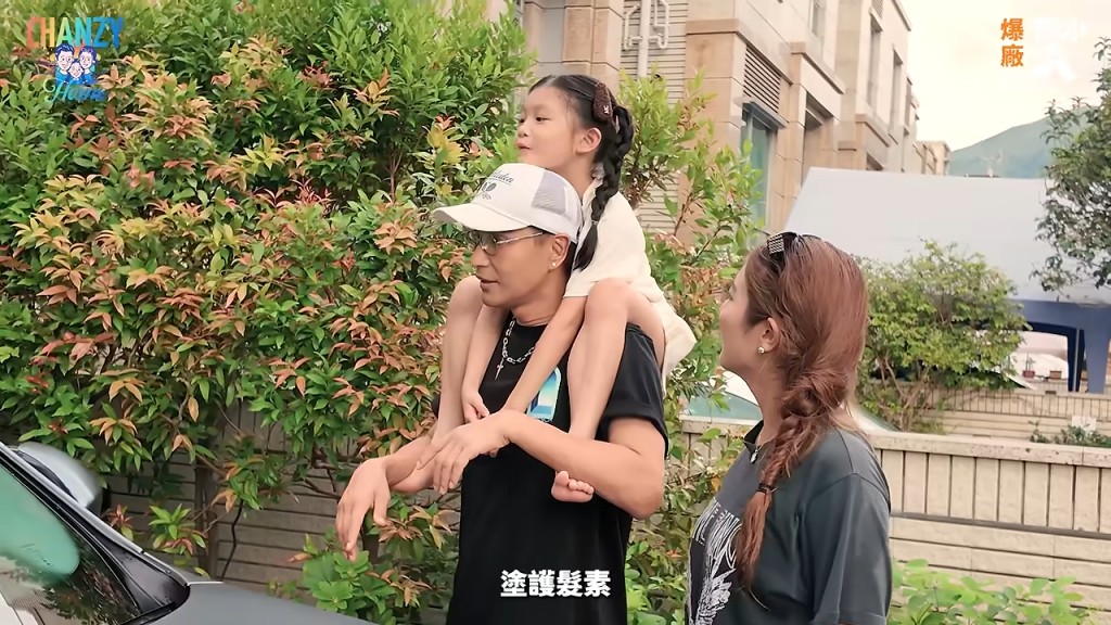 陳展鵬孭著女兒,與太太在屋外散步。 陳展鵬孭著女兒,與太太在屋外散步。