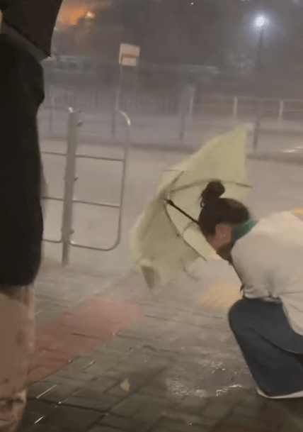 有市民在街頭面對暴雨，瑟縮一角。