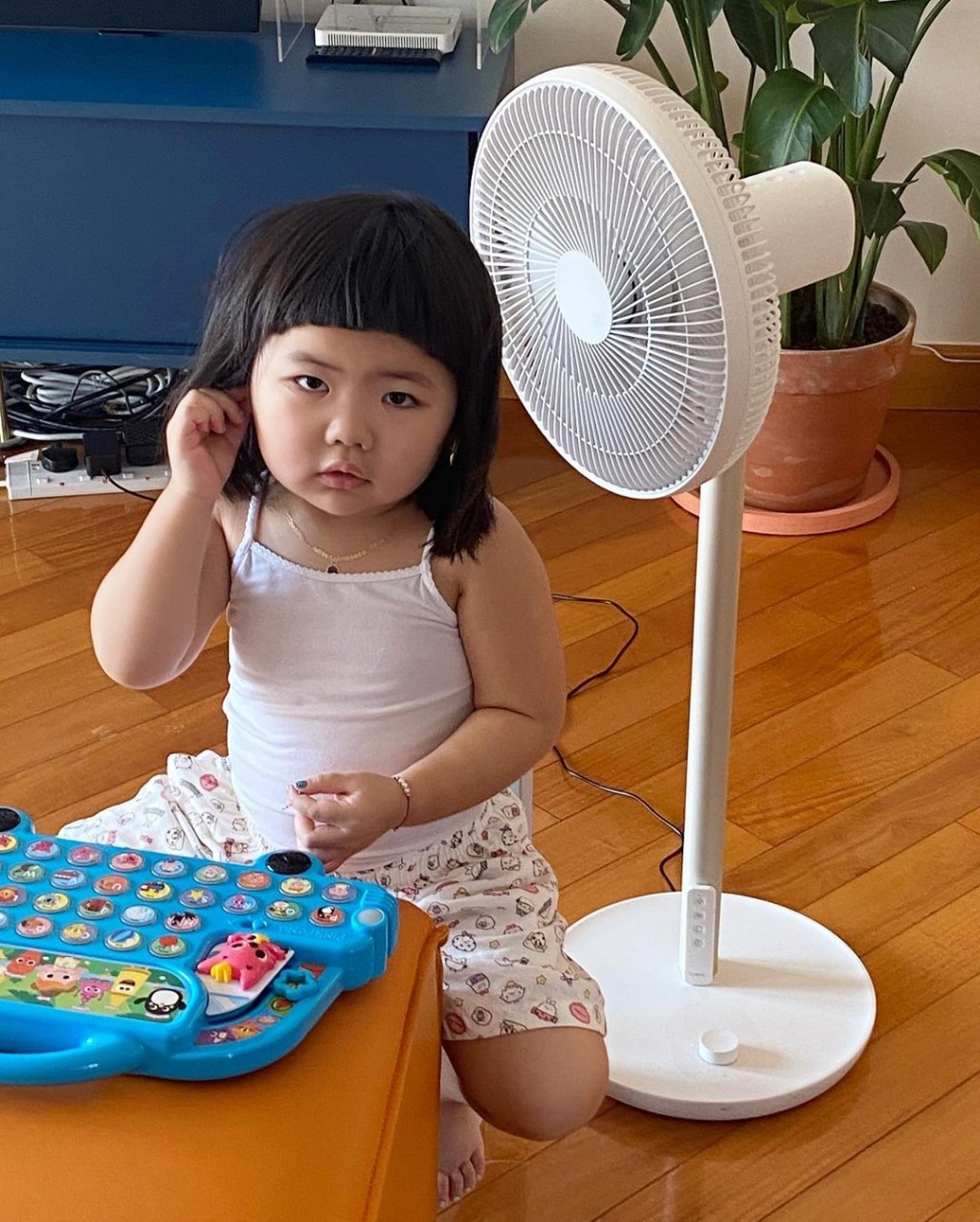 拎風扇對着後腦散熱。