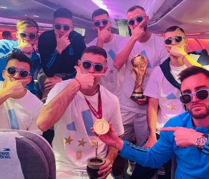 阿根廷球员乘飞机回国时，各人情绪高涨，不停与奖杯合照。网上图片