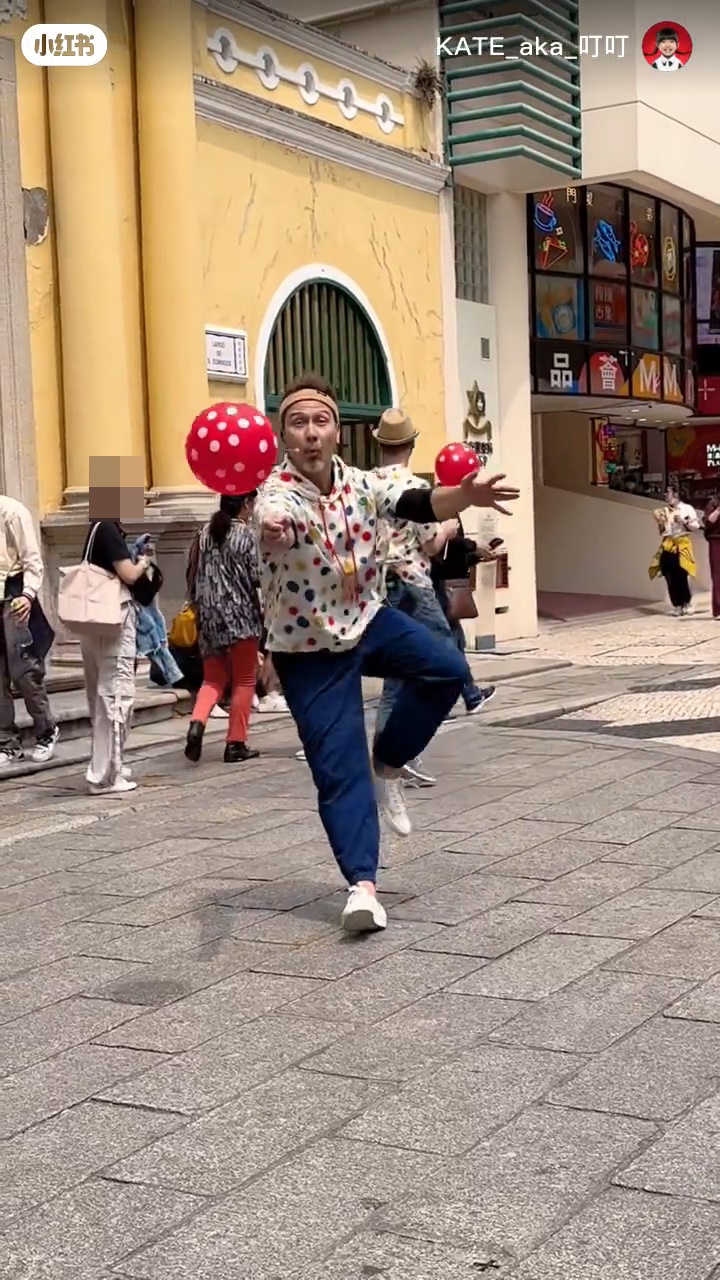 Julio拉着氣球像小丑表演，與圍觀的小朋友互動。