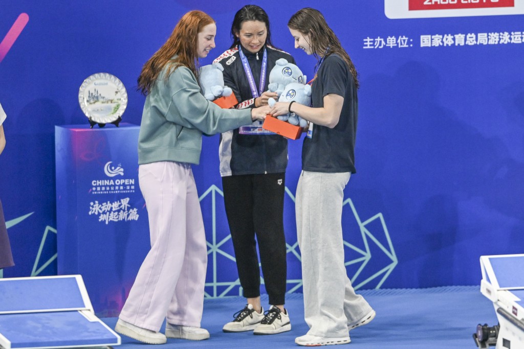 何詩蓓（中）在首日100米自由泳決賽中發揮出色，力壓強敵奪得金牌。中新社